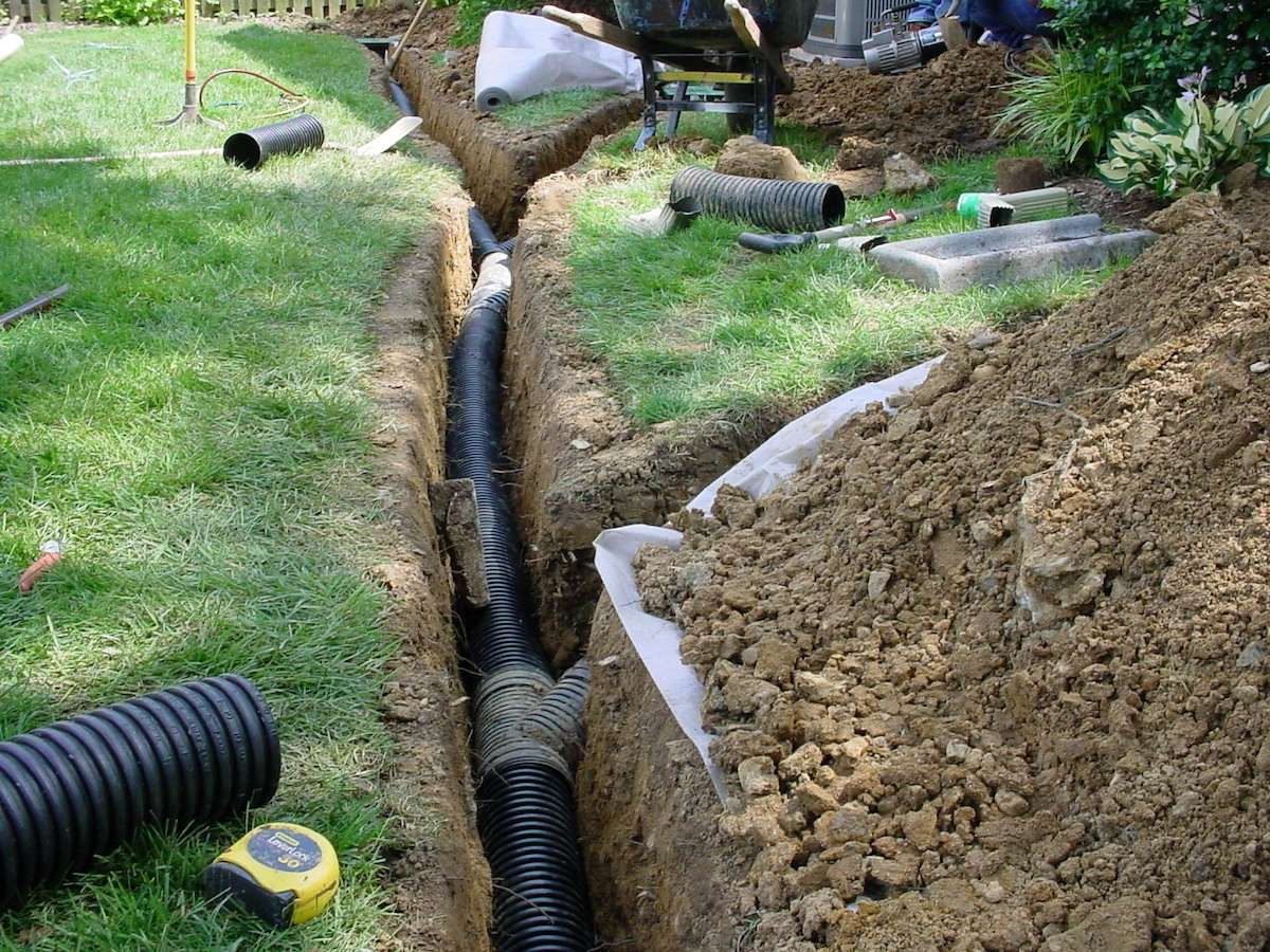 Drainage trench with perforated pipe and filter fabric installed in a residential yard