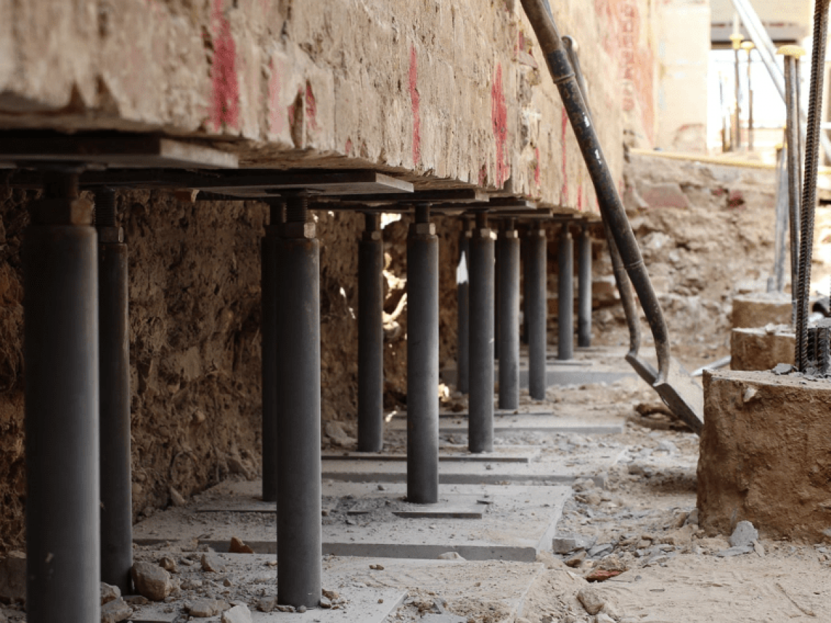 Steel underpinning posts supporting an excavated foundation wall during structural reinforcement